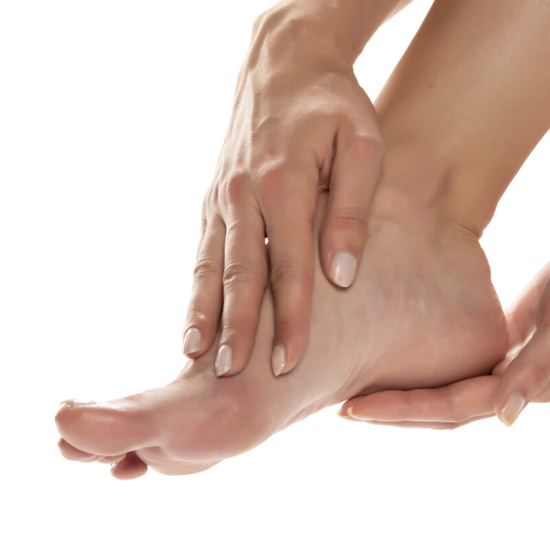 Foot massaged by two hands.