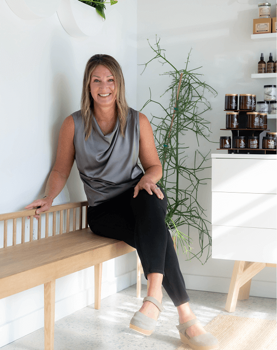 Julie, owner of Utopia Foot & Shoulder, smiling outside.
